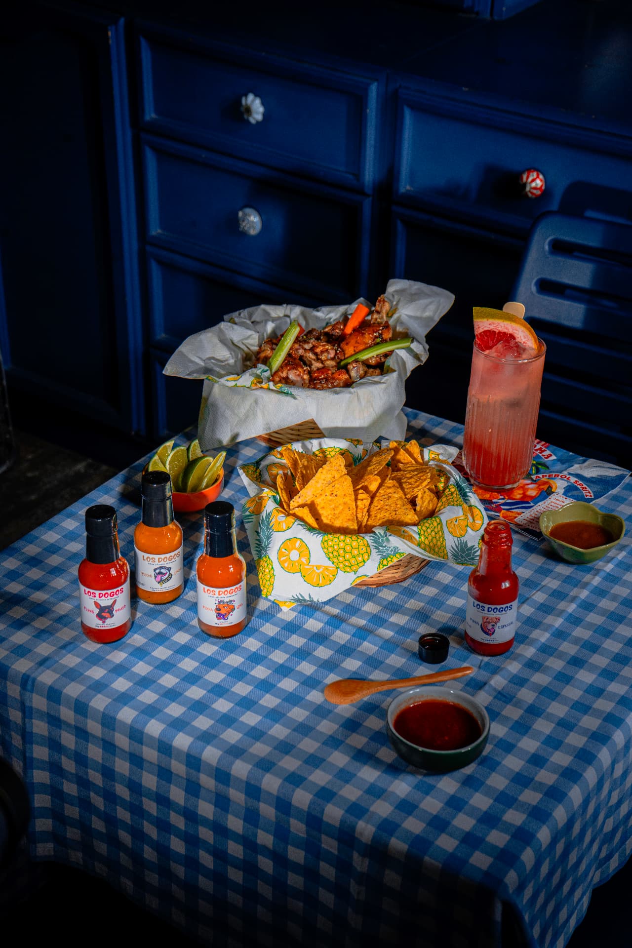 Mesa con salsas Los Dogos, alitas y nachos